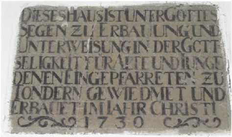 Indskrifttavlen fortæller om husets formål og byggeår.