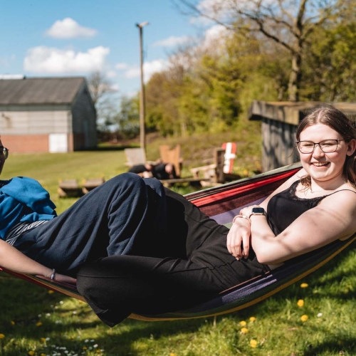 Elever ligger i hængekøje på efterskole outdoor område